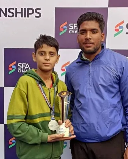 With one of my young, promising players and his trophy. Nurturing talent from a young age is my priority.