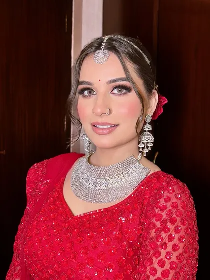 A close-up of Anjali's radiant smile. Her makeup is fresh and dewy, with a focus on skin that looks healthy and glowing. The simple bindi completes the look.