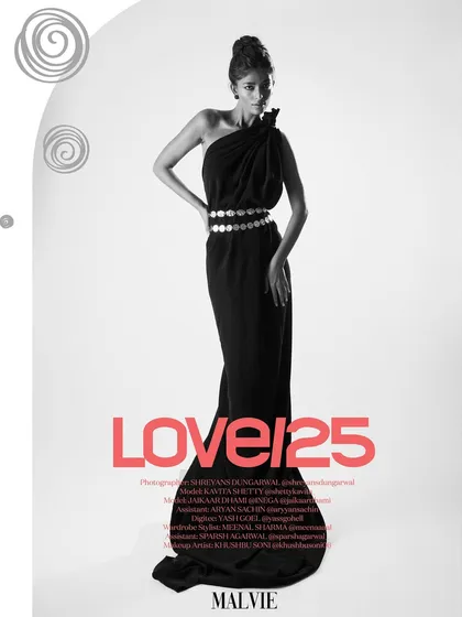 A striking full-length solo portrait from the couple's editorial, featured in Malvie's 'Love/25' issue. The black and white format emphasizes the elegant silhouette of the one-shoulder gown and the metallic shine of the coin belt.