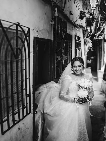 A candid black and white moment of the bride navigating the alley. This shot captures movement and the unique setting of a Mumbai wedding.
