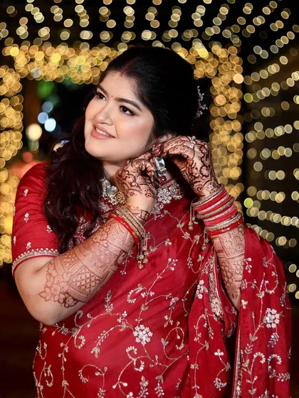 A candid moment as she puts on her earrings. The background bokeh and her radiant makeup create a magical, picture-perfect reception memory.