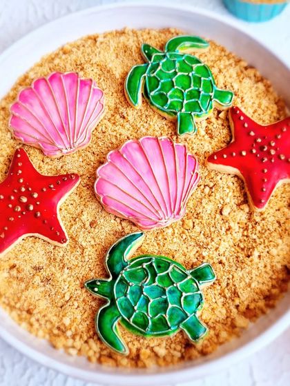 A set of beautiful underwater-themed sugar cookies, including turtles, starfish, and shells, decorated with stained-glass effect icing.