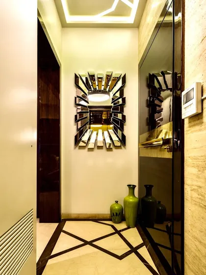 Every home needs a grand entry. This marvelous foyer features a bold, geometric-patterned floor, a stunning sunburst mirror, and a sleek glass door, creating a powerful first impression.