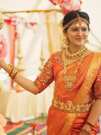 A candid shot of a model in our full Muhurtham jewellery set, including the traditional headband, layered necklaces, and Vaddanam. Perfect for a classic bridal look.