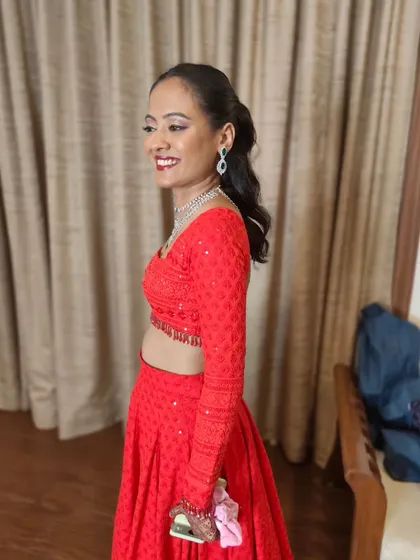 A modern Sangeet look featuring a sleek high ponytail and a bold red lip. This style is chic, comfortable, and perfect for a bride who wants to dance the night away.