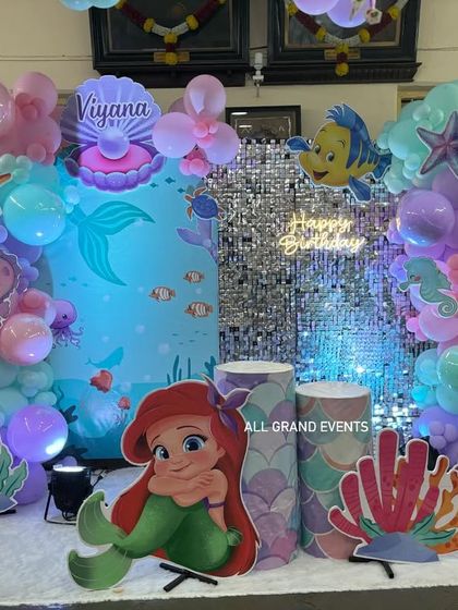 The lighting plays a key role in setting the mood. Here, blue uplighting enhances the underwater theme of the Little Mermaid birthday party.