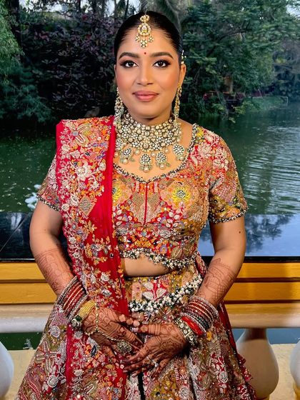 A happy and radiant bride, her makeup looking fresh and glowing by the water.