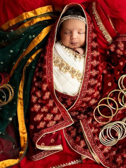 A duplicate of image 91, capturing a beautifully styled newborn Radha portrait with traditional Indian accessories like bangles and a decorative dupatta.