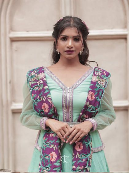 A full-front view of the turquoise lehenga, showcasing the flattering peplum blouse and the beautiful drape of the skirt.