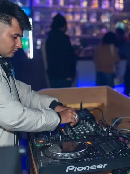 A close-up of the DJ in action, focused on mixing the perfect set for the crowd.
