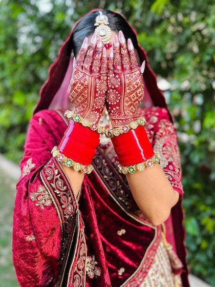 A bride hiding her face behind her beautifully stained hands. This classic pose really shows off the intricate design and the deep color.