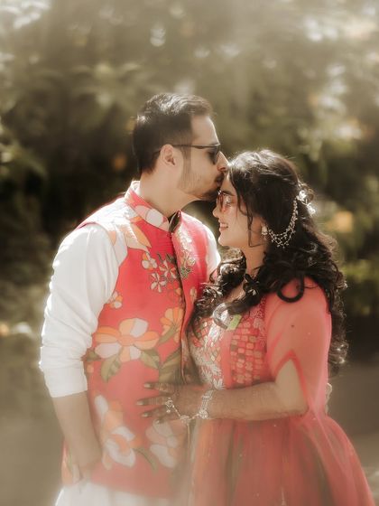 A tender kiss on the forehead. This classic romantic gesture, captured in soft, natural light, creates a timeless and emotional portrait of the couple.