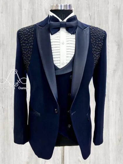 Feel like a modern-day gentleman in this bespoke navy tuxedo. The textured shoulder detail adds a unique touch to a classic design.