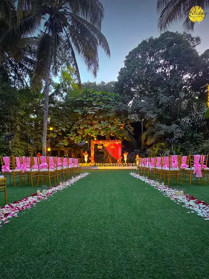 An evening ceremony setup on our lawn, with chairs adorned with pink ribbons, ready for guests to witness a beautiful union as the sun sets.