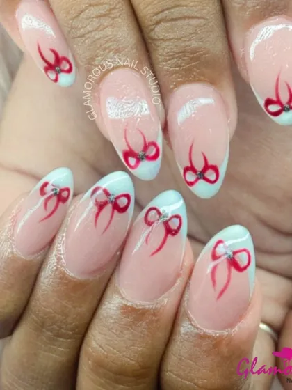 Tie it all together with a bow. This super cute design features a modern French tip with a twist, and delicate, hand-painted red bows on the accent nails, each finished with a tiny rhinestone.