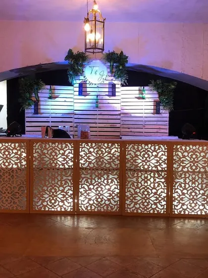The bar is often the heart of the party. We designed this custom bar counter with an elegant backlit lattice front and a personalized logo, making it a stylish and central spot for guests to gather.