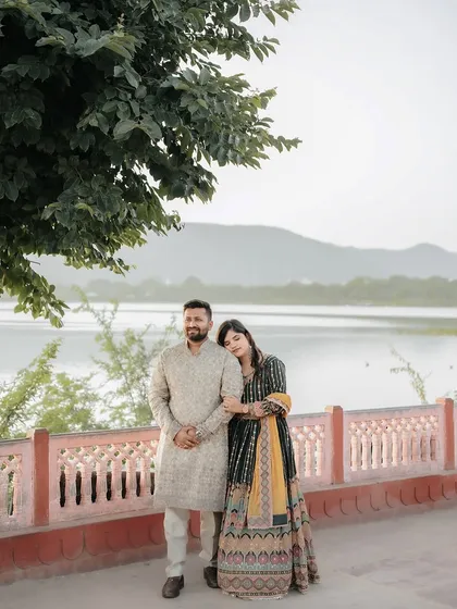 A quiet, peaceful portrait of the couple by the lake, with the bride resting her head on the groom's shoulder.
