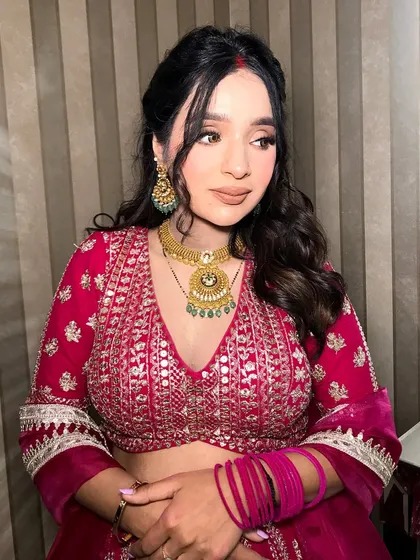 Another angle, showing her soft curls and the intricate design of the necklace.