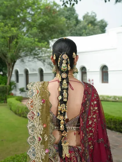A bridal look is incomplete without the perfect hairstyle. This image showcases an intricate traditional braid, adorned with beautiful gold ornaments, a testament to the detailed work my hair team and I provide.