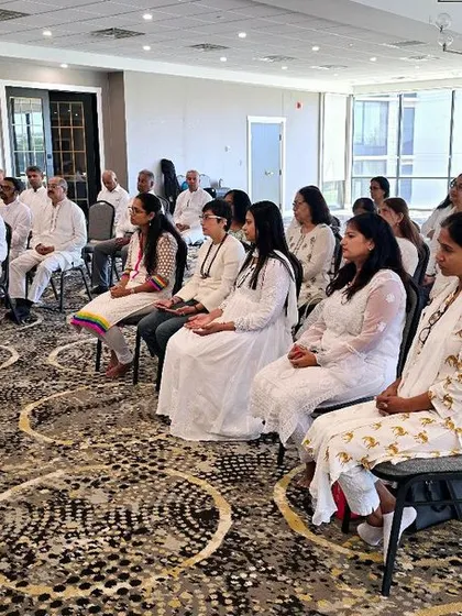 A group of participants dressed in white, symbolizing purity, engage in a meditation session during our program in Pennsylvania, USA. The shared intention of the group amplifies the meditative experience.
