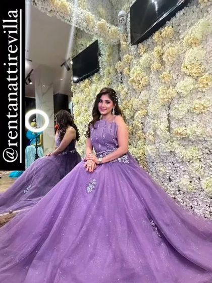 A client trying on a lovely lavender gown in my studio, sitting in front of a flower wall. It's a perfect spot to see how you'll look in photos.