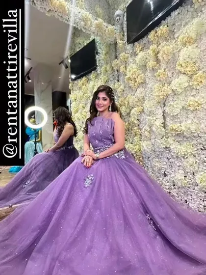 A client trying on a lovely lavender gown in my studio, sitting in front of a flower wall. It's a perfect spot to see how you'll look in photos.