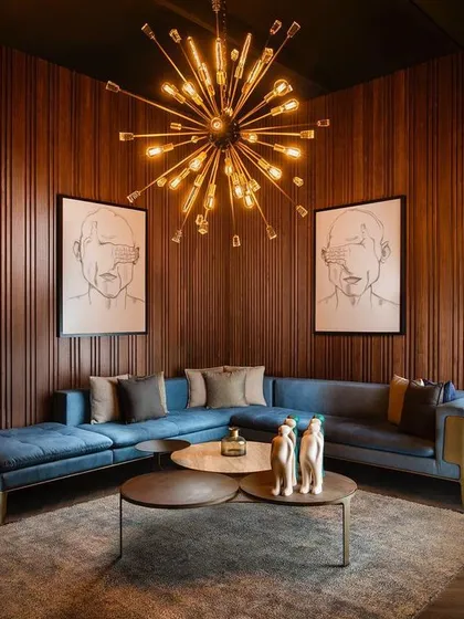 I designed this living room to feel both grand and intimate. The vertical wood wall panelling provides a warm, textured backdrop that envelops the space, creating a sophisticated sanctuary for relaxation and conversation.