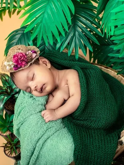 Your newborn's first photoshoot should be as unique as they are. I designed this tropical-themed setup with lush greens and a cozy basket to create a peaceful, artistic portrait of this sleeping baby.