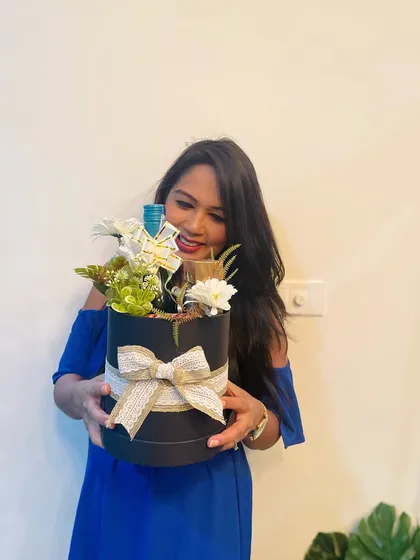 A happy client with her custom hamper in a black round box. I love seeing the joy my creations bring.