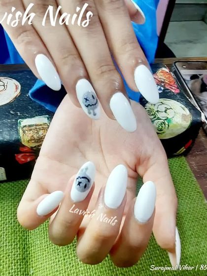 A spooky-cute design with long white almond nails and a hand-painted character accent.