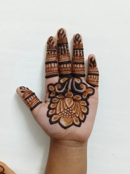 The back of the hand, showing the fresh henna paste. The journey to a beautiful stain starts here.