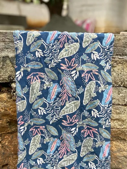 A finished piece of custom-designed fabric, ready for its new home. This seven-part discharge print on organic cotton, created for Wanderling Silk, shows a magical garden scene brought to life with plant-based resins and intricate layering.