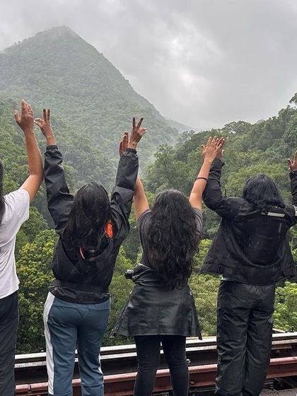 Arms raised in celebration against a stunning backdrop in Sakleshpura. This is the feeling of freedom and friendship that our community fosters.