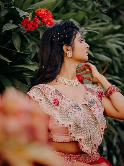 A side profile showing the half-up hairstyle with pearl details. This style is perfect for keeping hair off the face while still looking glamorous.