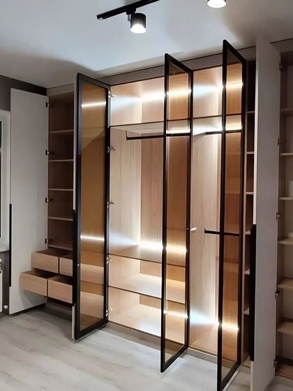 This perspective showcases how the wardrobe integrates with the room's architecture, fitting perfectly next to a window. The open doors reveal the depth and versatility of the storage solutions within.