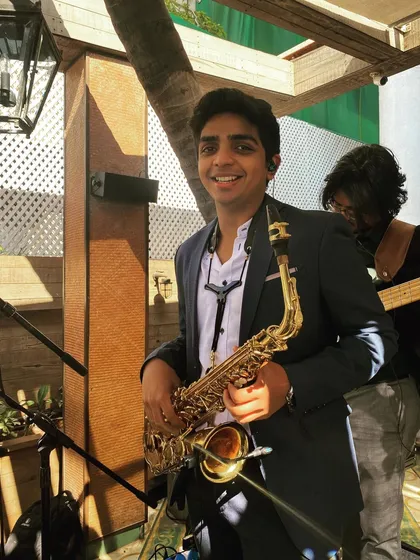 Our saxophonist Enrico, smiling before a performance. The saxophone adds a unique layer to our sound, and we love incorporating it into our sets.