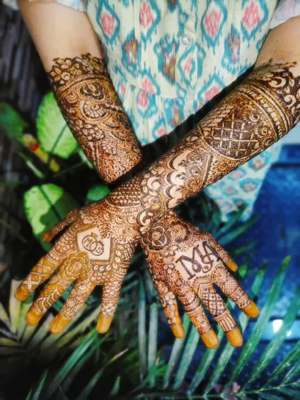 This intricate design was for bride Safeena's engagement day. We personalized it by weaving her and her fiancé's initials, 'M' and 'A', right into the pattern on her palms.
