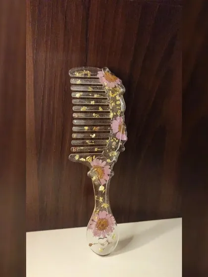 I also make fun and functional accessories like this floral resin comb. This piece features pretty pink daisy flowers and a sprinkle of gold flakes, turning an everyday item into a unique piece of art.