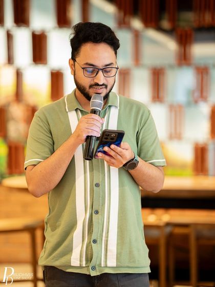 A poet reads from his phone, contributing his thoughts on the theme. The event was attended by over 50 participants, all there to listen and share.