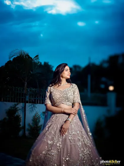 A beautiful portrait of the bride-to-be against the deep blue of the evening sky, showcasing her elegant gown and poised demeanor.
