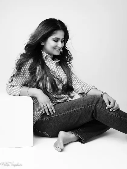 A candid black and white moment from the same session. Looking down with a soft smile, this image feels intimate and authentic, capturing a quiet moment of reflection.