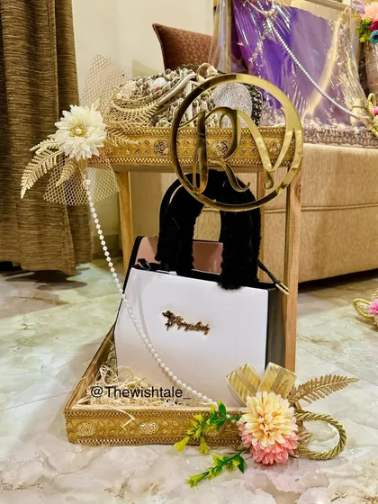 It's all in the details. For this trousseau, I created a special display for the bride's handbag, decorating it with delicate flowers, pearls, and a custom gold acrylic initial to make it feel extra luxurious and personal.