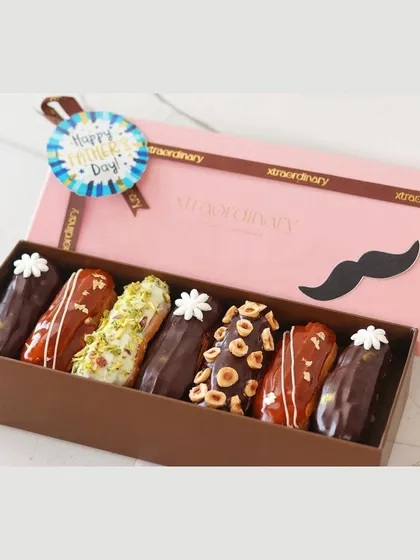 A top-down view of the assorted eclairs for Father's Day, showcasing the different toppings like hazelnut, pistachio, and chocolate drizzle.