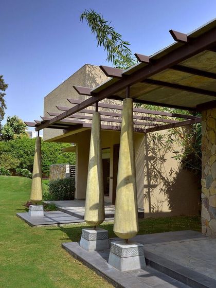 The sculptural columns supporting the entrance pergola at C Farm. These forms are inspired by traditional Indian crafts but are reinterpreted in a contemporary material and scale, creating a unique design signature.