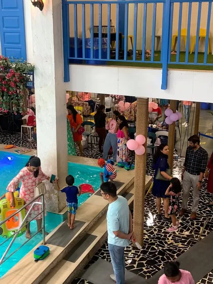 Embracing the happy chaos of a kids' party. This overhead view captures the lively atmosphere as families mingle by the poolside.