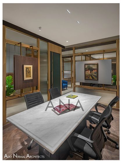 The conference room at Jain Cosphere Office is designed for 4-6 people, with a glass partition that uses both clear and fluted glass for privacy. A central panel is cleverly utilized to display artwork.