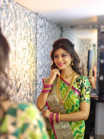 The model admiring the finished makeup look in the mirror. This is the moment of confidence we aim to create for every client and teach every student.