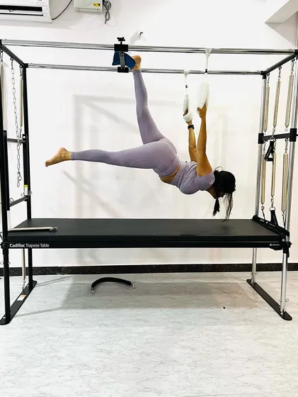 This client demonstrates incredible upper body and core strength, holding a one-armed pose on the Cadillac trapeze.