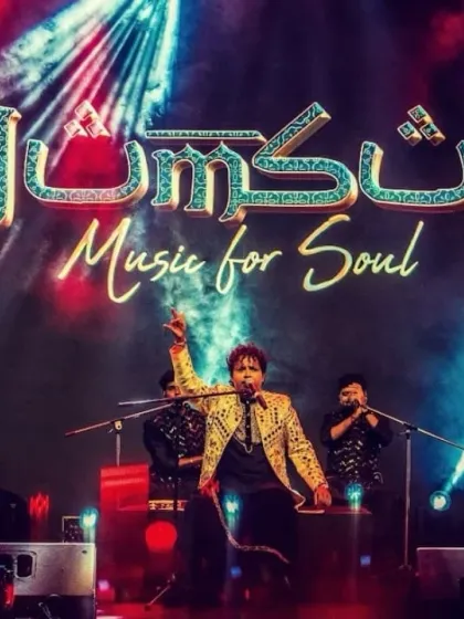 The full band, owning the stage at a grand corporate event.