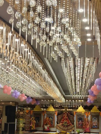The ceiling of the banquet hall, decorated with pink and purple balloon bunches to match the butterfly theme and add to the festive atmosphere.